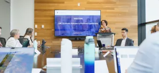 A group of people in a meeting room, with an instructor presenting about the GDPL on a TV screen.