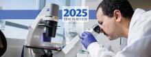 A researcher looking into a microscrope, overlaid with the text "2025 Year in Review".