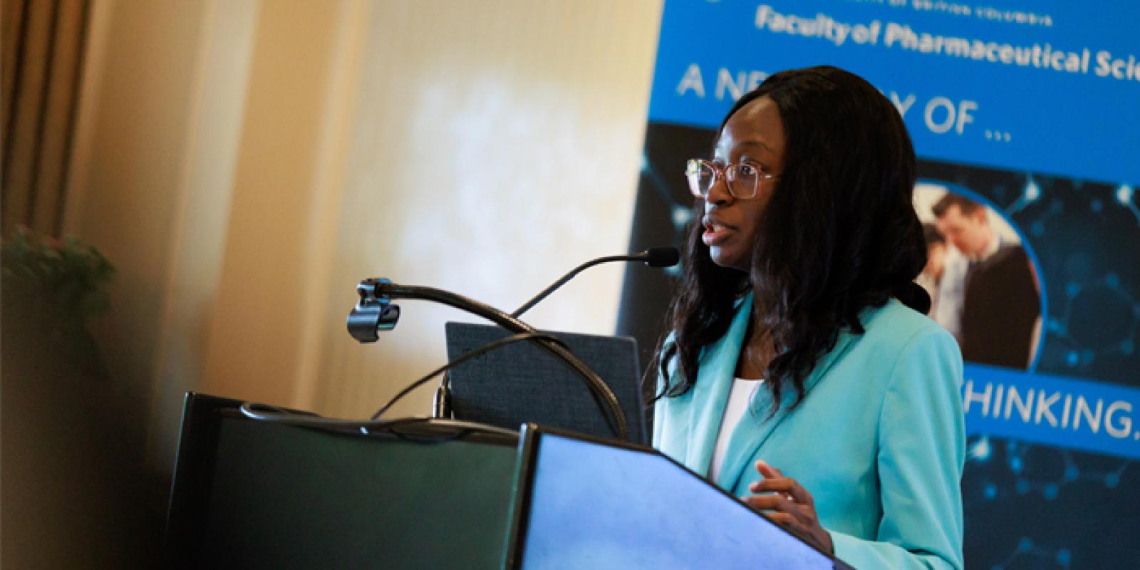 A health care professional standing and presenting at a podium.