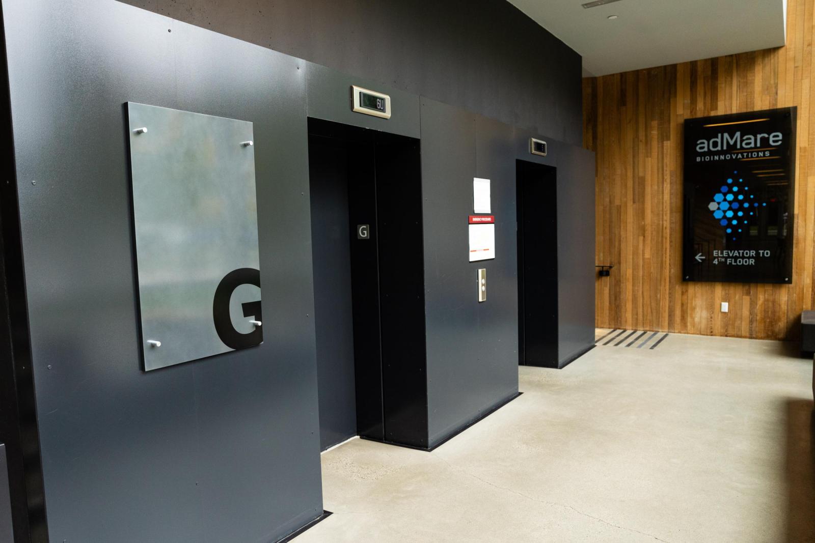 A photo of the elevators on the ground floor of the UBC Pharmaceutical Sciences Building.