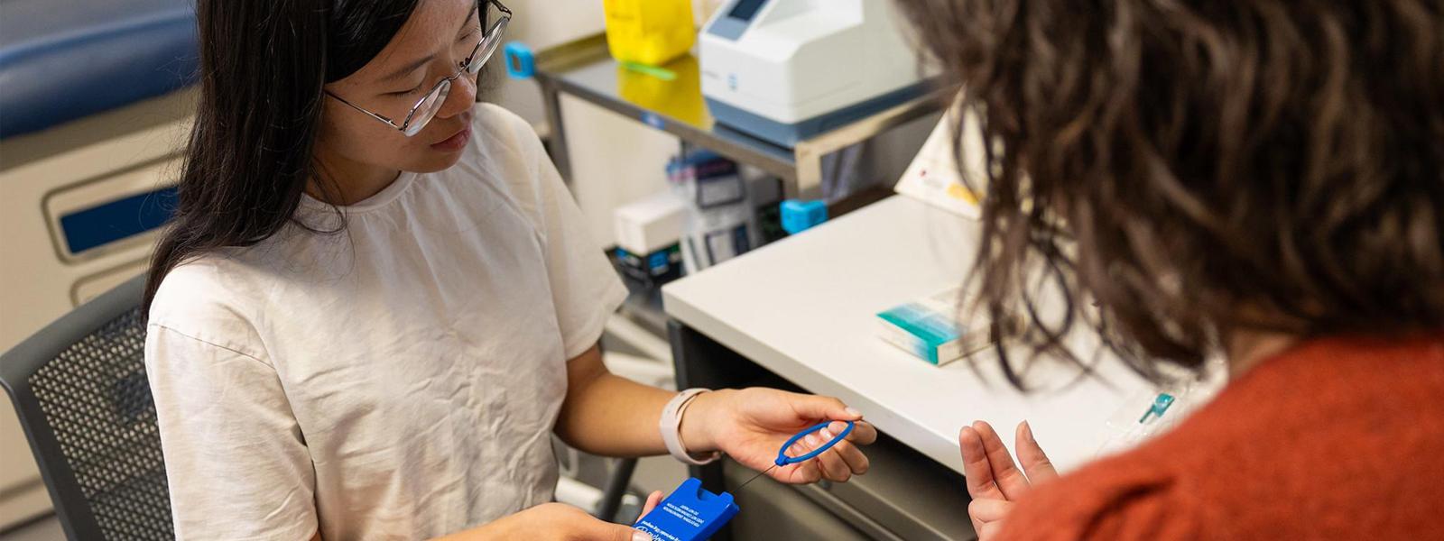 A pharmacist and a student sitting in a clinic office.